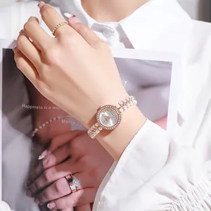 Detailed view of luxury women's watch with pearl strap and diamond-set bezel on wrist