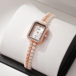 Close-up of vintage quartz watch with pearl strap and diamond-encrusted rectangle dial