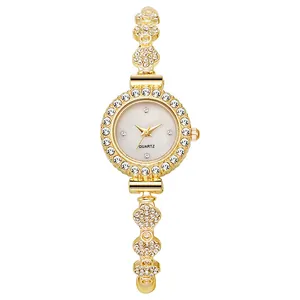 Close-up of gold quartz watch featuring a crystal bezel and petal-shaped bracelet links