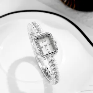 Vintage silver quartz watch with pearl chain strap and crystal bezel on white plate