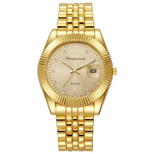 Macro view of gold-tone watch face with diamond markers and date magnifier window