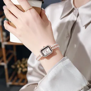 Elegant rectangular gold watch with rhinestone bezel and double-strand pearl bracelet