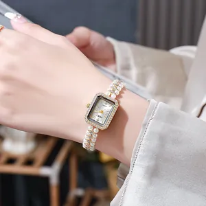 Detailed macro view of vintage pearl bracelet watch featuring a gold rhinestone case