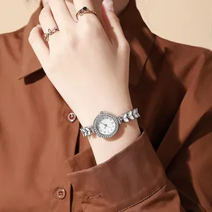 Détail d'une montre à quartz argentée avec lunette en strass et bracelet en feuilles