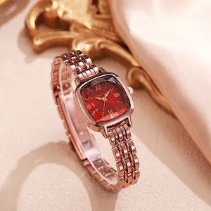 Elegant rose gold square watch with vintage red dial and metal link strap on pink silk