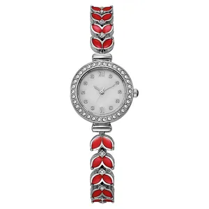 Détail d'une montre argent pour femme avec lunette sertie et bracelet à maillons émail rouge