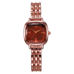 Detail of rose gold metal strap and wine red rectangular dial with roman numerals