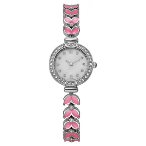 Détail d'une montre argentée pour femme avec lunette en cristal et maillons rose en feuille