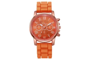 Detail of orange quartz watch dial with roman numerals and textured silicone strap