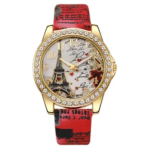 Détail de la montre à quartz dorée avec cadran Tour Eiffel et bracelet en cuir rouge