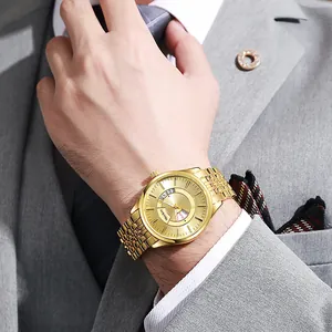 Close-up of a gold steel business watch with dual day-date display worn with a suit