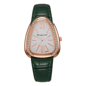 Détail du boîtier montre serpent or rose avec cristaux et bracelet en cuir vert foncé