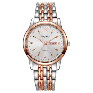 Detail of silver and rose gold steel watch face with day-date window and crystal markers