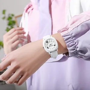 Close-up of white square quartz watch with celestial star and moon dial on wrist