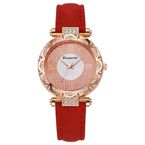 Detailed view of rose gold watch face with crystals and red suede strap texture