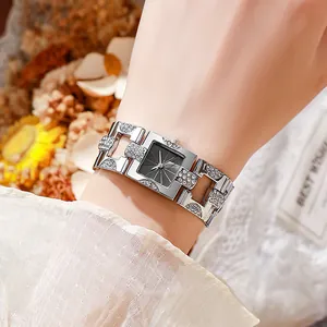 Elegante rechteckige Silberuhr mit Diamantlünette und Gliederkette am Handgelenk getragen