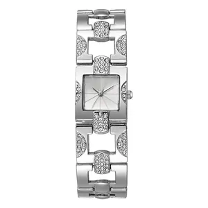 Detail einer quadratischen Silberuhr mit diamantbesetztem Metallarmband und Sonnenstrahlblatt