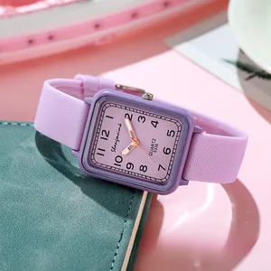 Detail of square purple quartz watch with silicone strap on a green notebook