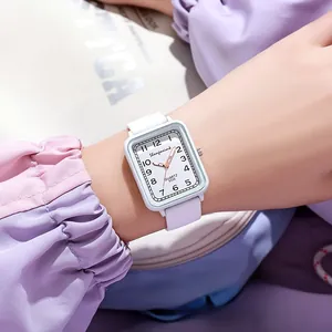 Close-up of light blue square quartz watch with white silicone strap on wrist