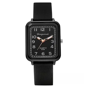 Detailed close-up of square black quartz watch face with rose gold hands and rubber strap