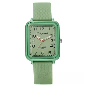 Detailed macro of a green square quartz watch featuring a textured silicone strap