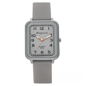 Detail of gray rectangular quartz watch with Arabic numerals and textured silicone strap