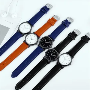 Flat lay of five minimalist quartz watches with leather straps and Arabic numeral dials
