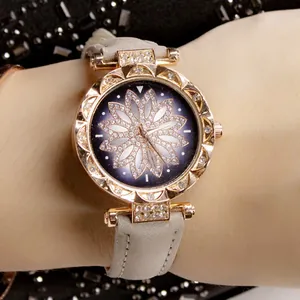 Dettaglio dell'orologio in oro rosa con lunetta diamantata e quadrante a fiori blu