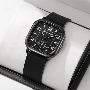Close-up of square black watch dial with embossed texture and soft silicone strap