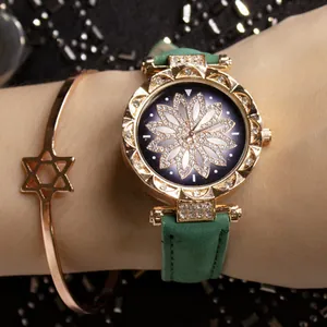 Dettaglio ravvicinato dell'orologio dorato con quadrante floreale e cinturino verde