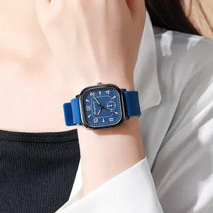 Close-up of square quartz watch with blue checkered dial and textured silicone strap