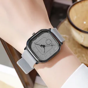 Detailed close-up of a square grey watch face with silicone strap on a wrist