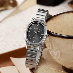 Women's quartz watch with oval silver case and black dial on a beige coffee cup