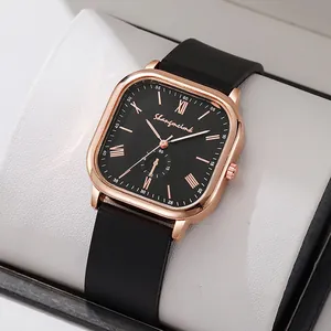 Détail d'une montre carrée or rose avec cadran noir et chiffres romains sur coussinet