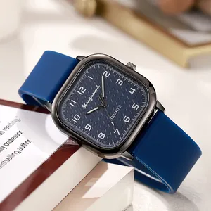Square blue quartz watch with silicone strap and textured dial on a desk background