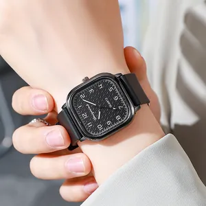 Close-up of a square quartz watch featuring a black textured dial and silicone strap