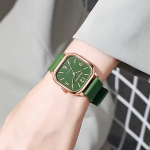 Detailed close-up of a vintage square quartz watch with green dial and rose gold metal case