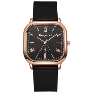 Détail du boîtier carré en or rose avec cadran noir à chiffres romains de montre quartz