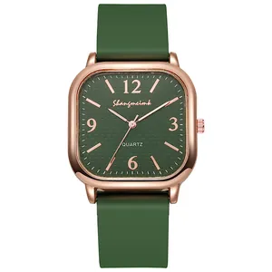 Close-up of square green quartz watch with rose gold case and green silicone strap