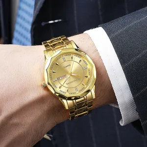 Close-up of gold quartz watch with double calendar and rhinestone markers on business suit