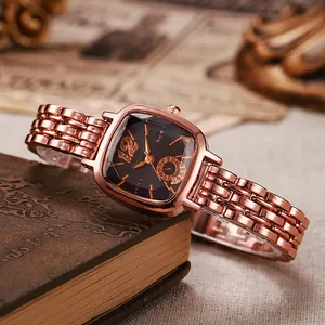Détail de la montre carrée or rose avec cadran noir sur livres anciens, bracelet élégant