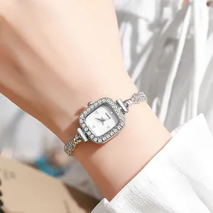 Gros plan d'une montre à quartz carrée argentée ornée de strass sur le poignet