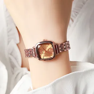 Vue macro de la montre carrée en or rose avec cadran champagne et bracelet métallique