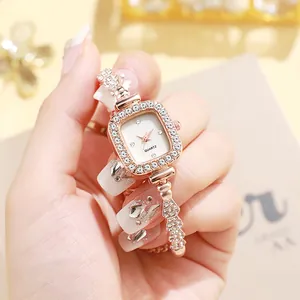 Gros plan sur une montre carrée en or rose avec des strass brillants sur le bracelet