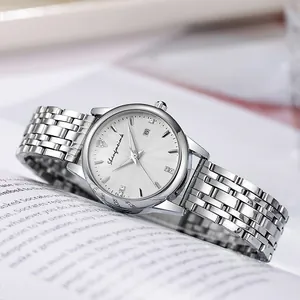 Close-up of silver quartz watch featuring date window and sunray dial on open book