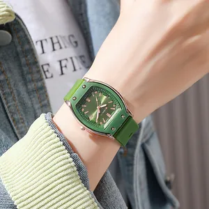 Detail of rose gold tonneau watch with green dial and sunray texture on wrist
