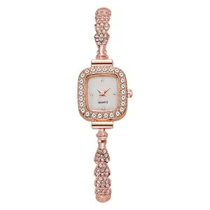 Gros plan sur la montre à quartz carrée or rose avec lunette sertie et bracelet strass