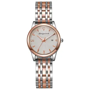 Detail of classic quartz watch featuring two-tone metal bracelet and white date dial