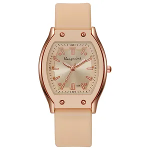Detail view of square rose gold watch case with silicone strap and screw accents