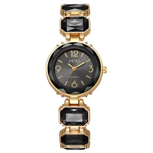 Détail de la montre quartz OUKI avec bracelet doré et cristaux noirs rectangulaires